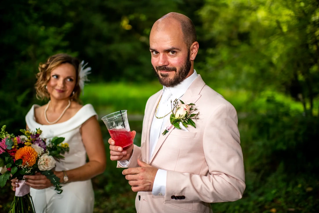 groom sips his cocktail and bride smiles nicely in the background Beautifully lit Horning's Hideout Wedding; Modern Art Photograph