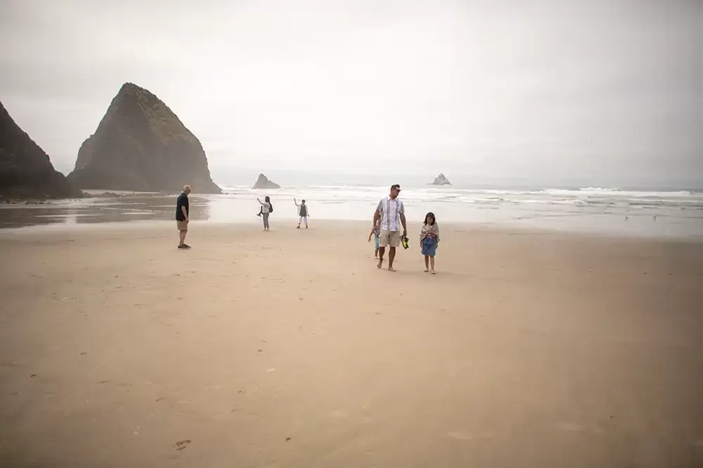 A family walks along the sandy beach together. The ocean is by their side.Portland ​Family Photographer Robert Knapp - Book Today! ​Family Photographer Robert Knapp in Portland - Book Today!