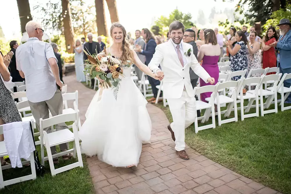 Portland Wedding Photographer Robert Knapp Catches a wonderful moment where a bride and groom are just married and are running away from the ceremony happy as ever.