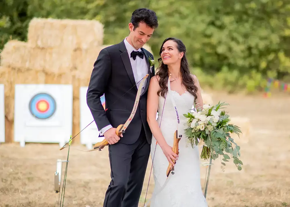 bride and groom stand with archery gear at A ​Sauvie Island Wedding from Photographer ​Robert Knapp 