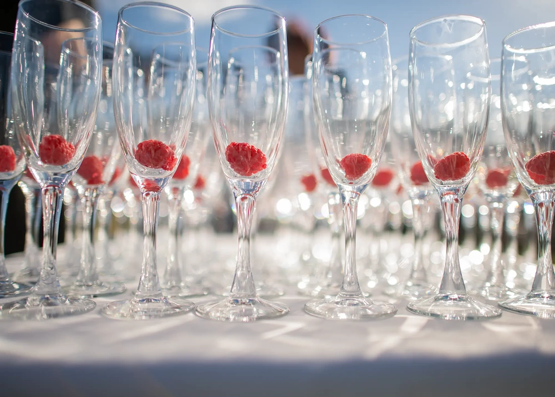 ​Sauvie Island Wedding  from  Photographer ​Robert Knapp  sparkling wine glasses with raspberries inside fill the frame at A Sauvie Island Wedding from Photographer Robert Knapp
