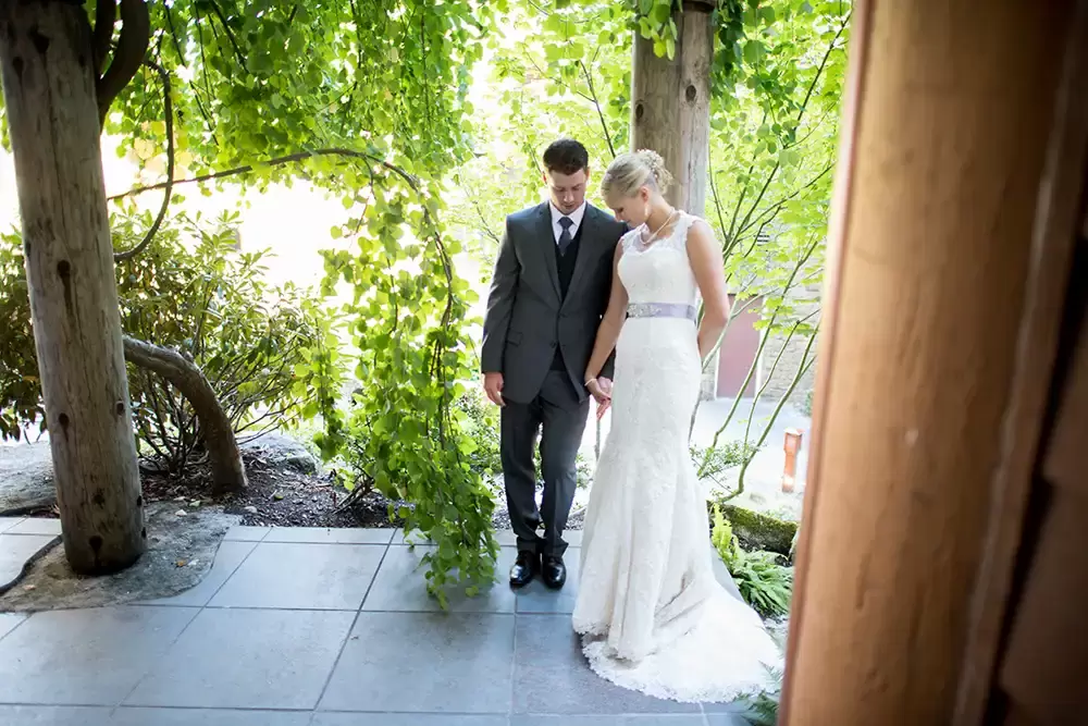 Alderbrook Resort Weddings
from ​Photographer Robert Knapp Bride and groom lien against beam, holding each other's hands the trellis has them in the shade. The wisteria vines are overhead.