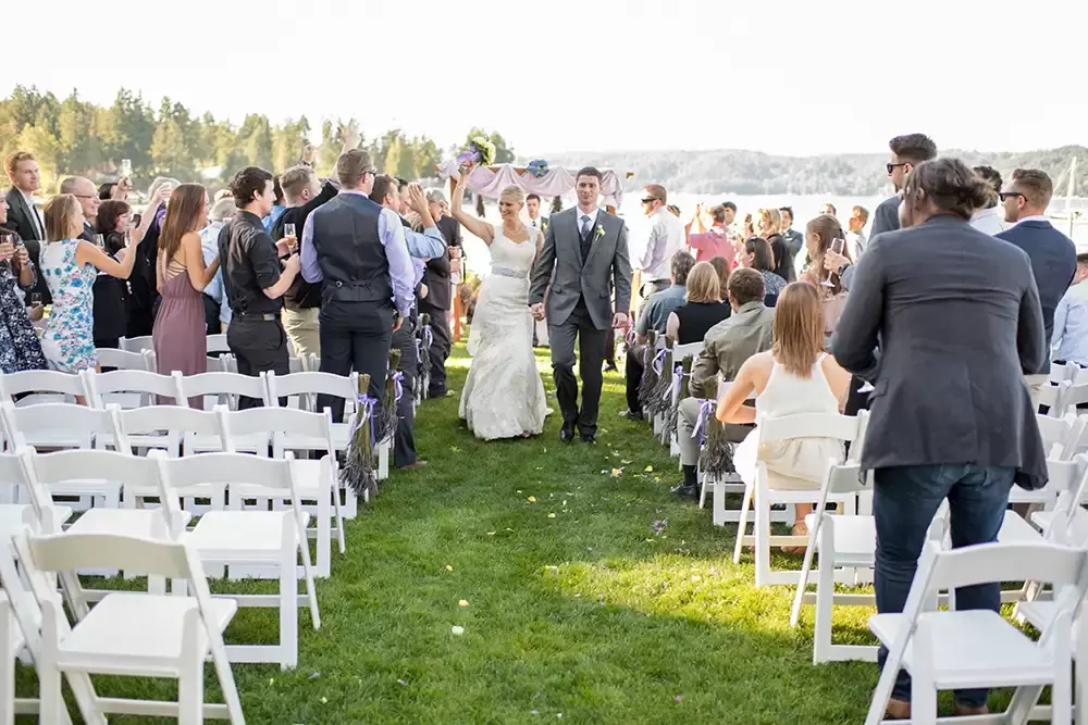 Alderbrook Resort Weddings with photographer Robert Knapp, bride and groom hold hands and walk down the aisle together