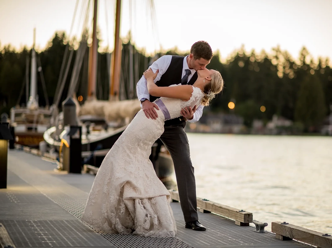 Bride and groom kissing at sunset on the dock at Alderbrook Resort Weddings