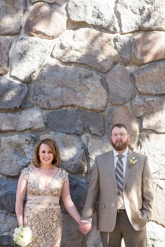 Wedding at Timberline Lodge ​from photographer Robert Knapp bride and groom stand in dappled sun against the lodge masonry