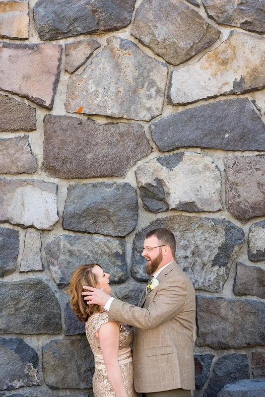 Wedding at Timberline Lodge bride and groom stand against a stone exterior