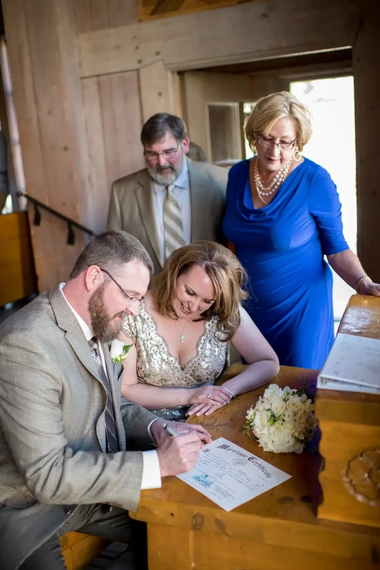 Wedding at Timberline Lodge the bride and groom sign the marriage certificate 