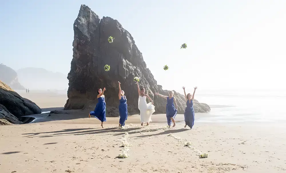 Wedding on the Beach
Cannon Beach Wedding
Photographer Robert Knapp bride and bridesmaids through their bouquets into the air. They jump, they are all smiling. 