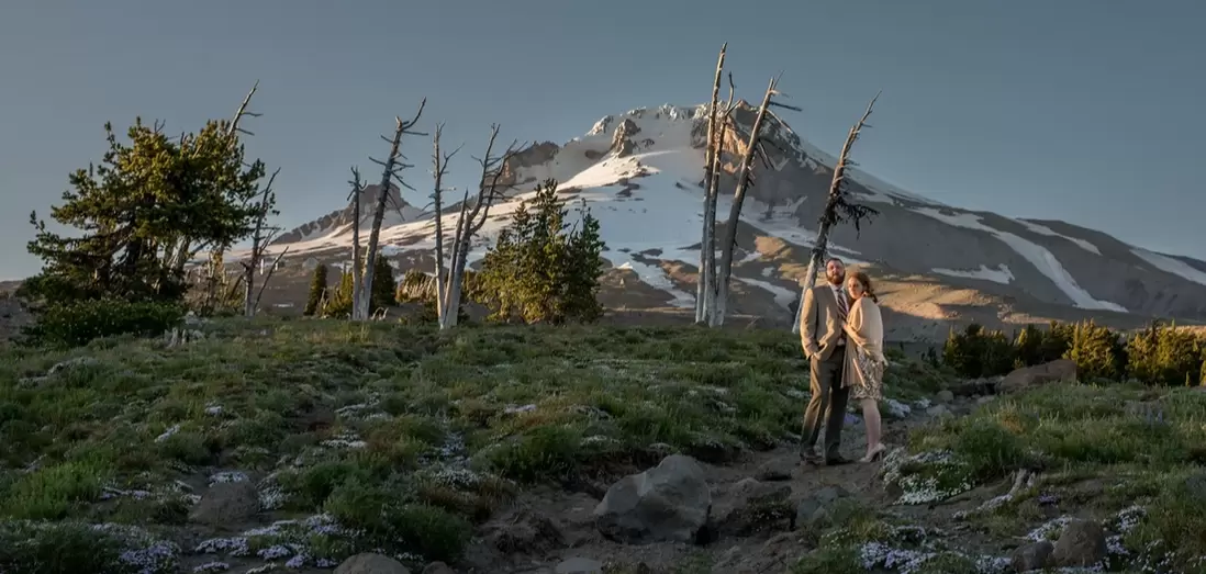 Wedding at Timberline Lodge ​from photographer Robert KnappA bride and groom stand in front of Mount Hood at sunset as seen from a wedding at timberline lodge