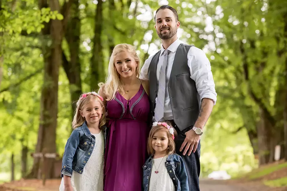 out of focus trees make a good background for this family photo Garden Photoshoot with Robert Knapp one of the highly sought after Family Photographers Portland has to offer