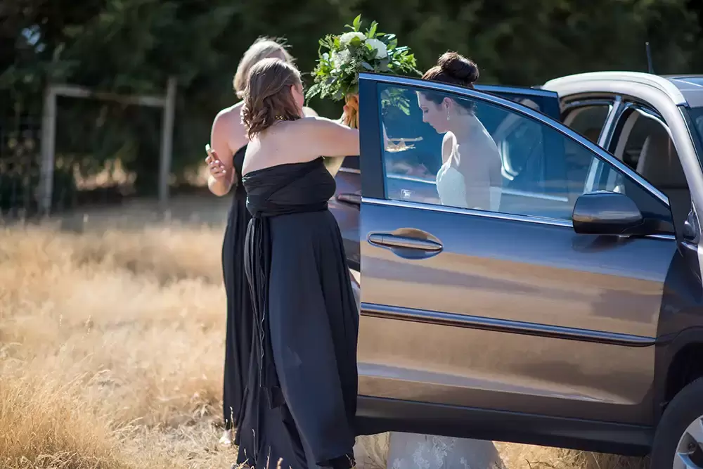 Farm Wedding Oregon
Rustic ​Chic Style with Robert Knapp Photographer the bride exits the passenger side of a car. Her bridesmaids assist her preparations for the first look. 