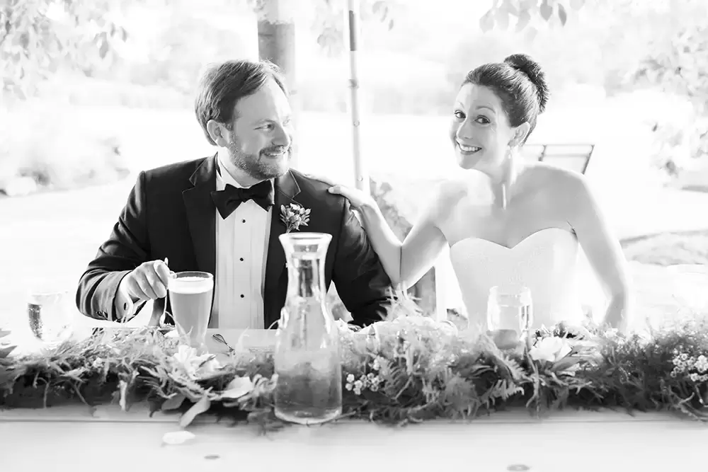 bride and groom sit at a sweetheart table for the reception