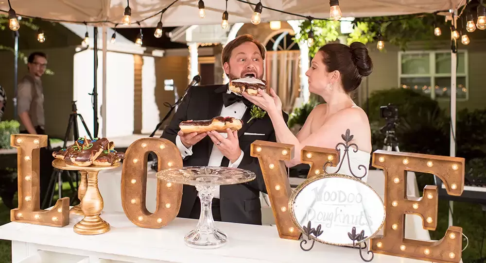 Farm Wedding Oregon
Rustic ​Chic Style with Robert Knapp Photographer voodoo doughnuts wedding photos as a man sinks his teeth into a doughnut being held by a woman in a wedding dress. 
