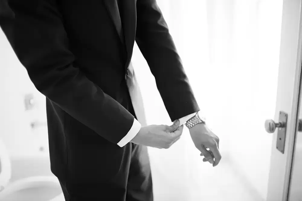 Hotel Deluxe Wedding in Portland Oregon
by Photographer Robert Knapp groom pulls the cuff of his shirt below the cuff of his jacket