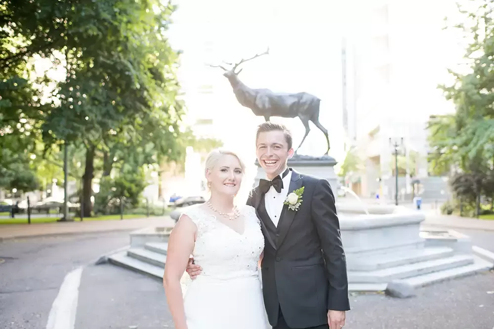 Hotel Deluxe Wedding in Portland Oregon
by Photographer Robert Knapp a bronze stag stands over the bride and groom smiling at the camera