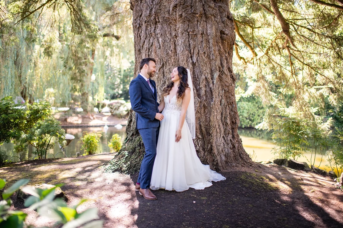 Lakeside Garden Wedding a couple stands in front of an old growth tree 