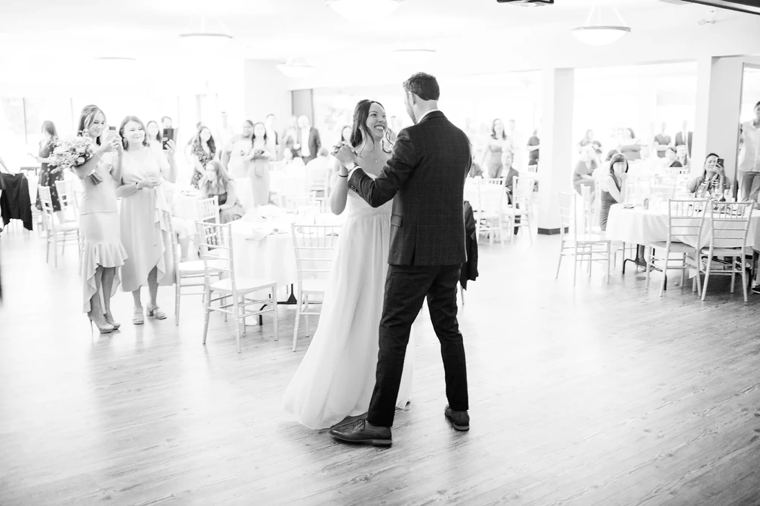 bride and groom first dance together at a lakeside garden wedding 