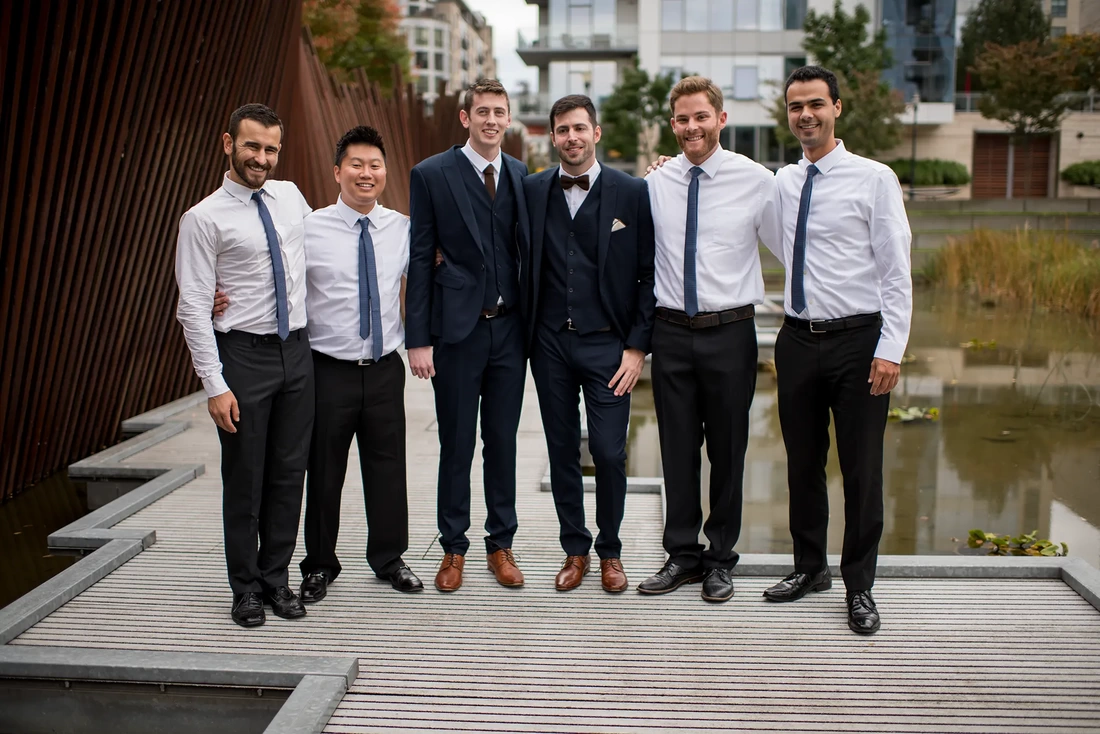 the wedding party stands in tanner springs LGBT Wedding Photographer Robert Knapp at ​Tanner Springs Park in Portland Oregon