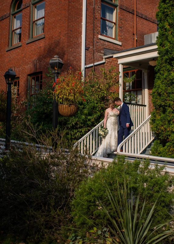 McMenamins Edgefield Weddings are great for wedding photography. use the entire property for our studio. Pictured here a bride and groom stand on steps together the railings, landscaping and building all texture to and interesting sceene.