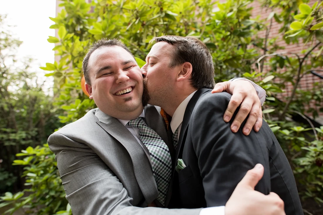 ​McMenamins Grand Lodge Weddings  from Robert Knapp PhotographerThe best man kisses the groom on the cheek. The from smiles but might not be too happy about it. 
