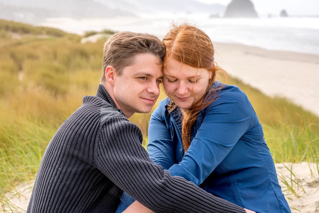 a couple nuzzle in the dunes above the beach Modern Art Photograph Engagement Photography Portland Oregon​