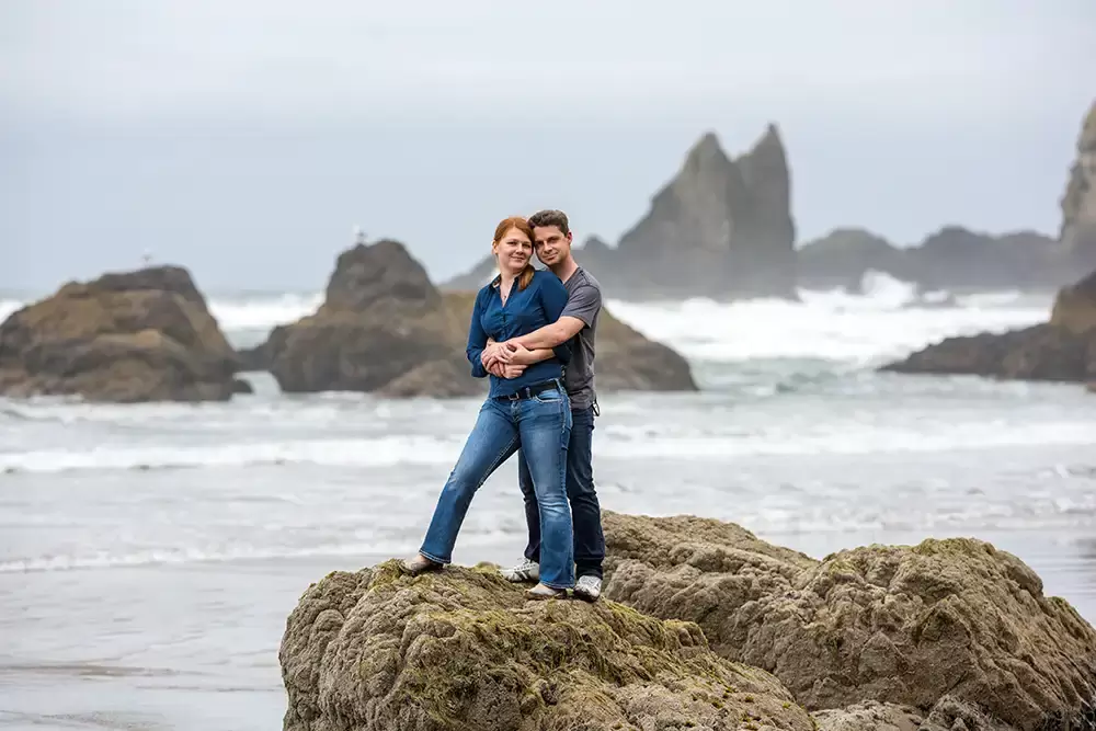 a couple stands on the rocky shore of the oregon coast Modern Art Photograph 
Engagement Photography Portland Oregon