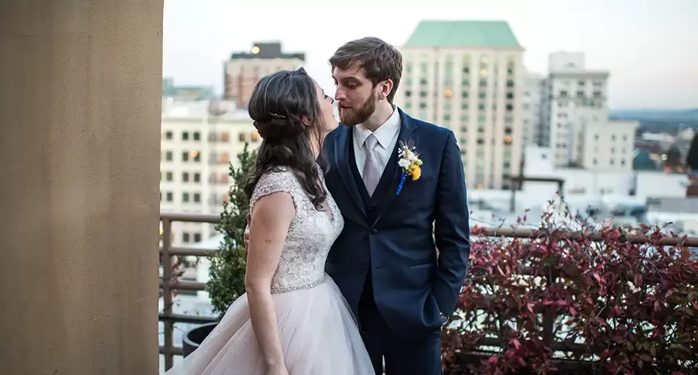 bride and groom kiss on a balcony overlooking the city of portland as photographed by ​​Modern Art Photograph 
Wedding Photographers in Portland
on location at the 
Portland Sentinel Hotel