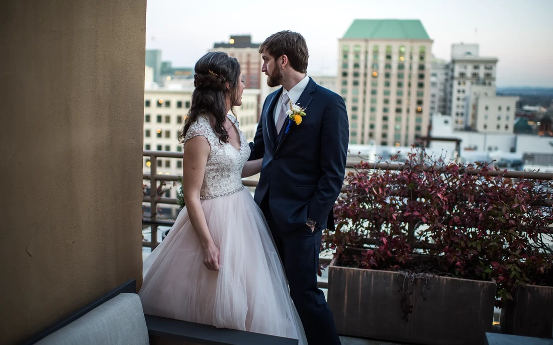 Wedding Photographers in Portland on location at the  Portland Sentinel Hotel bride and groom stand on a balcony overlooking portalnd, photographed by Wedding Photographers in Portland shooting on location at the Portland Sentinel Hotel