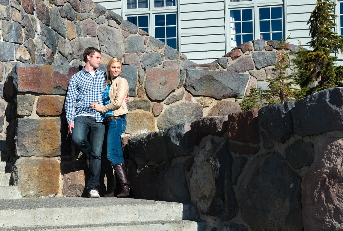Mountain Engagement Photos with a couple at a vintage lodge standing on the stone steps 