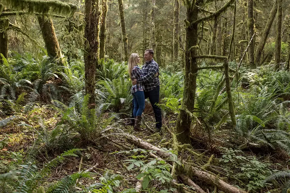 a couple stands in the thick of the woods together holding each other Oregon Coast Engagement Photos 
With 
Modern Art Photograph