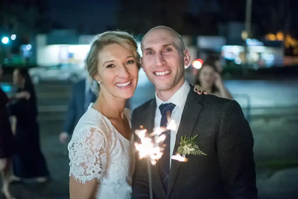 Oregon Wedding Photographers at Modern Art Photograph on location at opal 28 Bride and groom hold a sparkler smile and looked at the camera