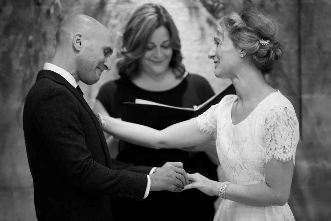 Groom places the ring on his brides finger, both are in tears. Oregon Wedding Photographers