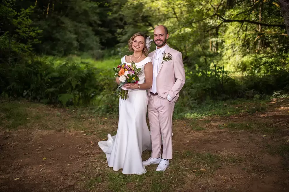 Photographers Portland at Hornings hideout Bride and groom wearing bright light colors against a dark background