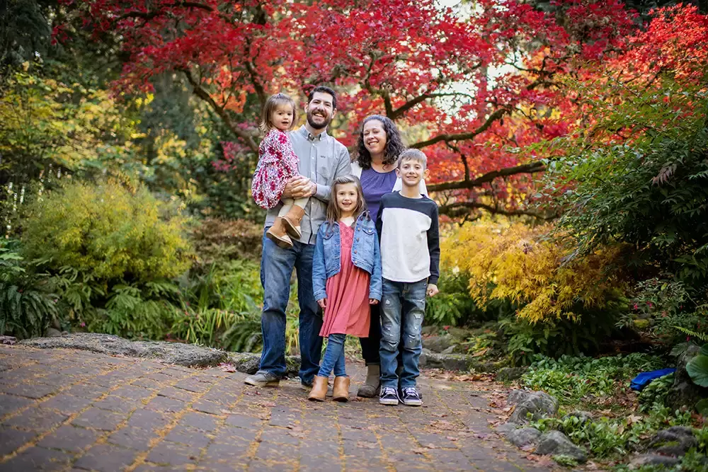 Portland Oregon Family Photographer Robert Knapp takes a photo of a family on a crooked path in front of some autumn colors on the trees 