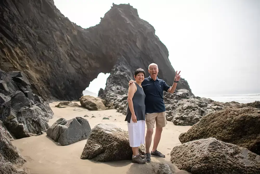 grandma and grandpa pose in front of a great arch in the cliffs Portland ​Family Photographer Robert Knapp - Book Today!