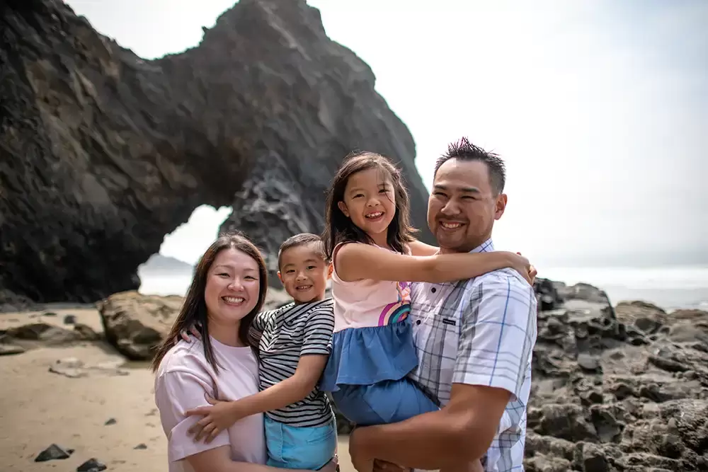 a family stands on the beach together with cannon beach family photographer Portland ​Family Photographer Robert Knapp - Book Today!