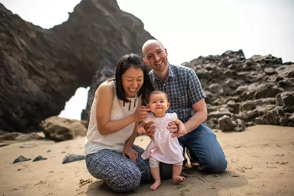 mothers smile is much brighter now that baby is smiling for the camera, the background is an interesting rock formation. Portland ​Family Photographer Robert Knapp - Book Today!​Family Photographer Robert Knapp in Portland - Book Today!
