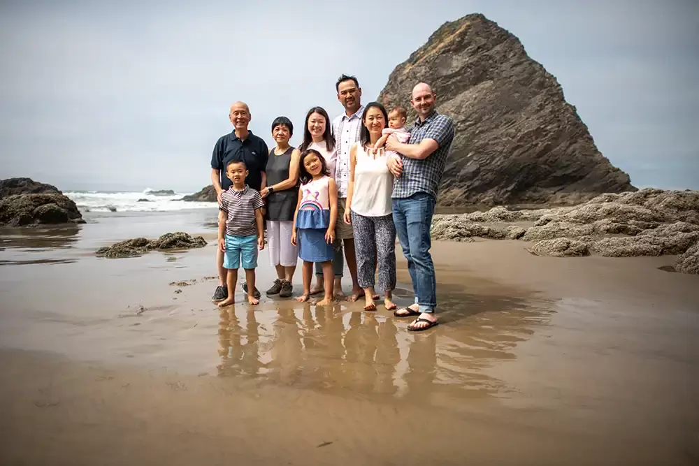 a family stands together in the sand on the beach Portland ​Family Photographer Robert Knapp - Book Today!​Family Photographer Robert Knapp in Portland - Book Today!
