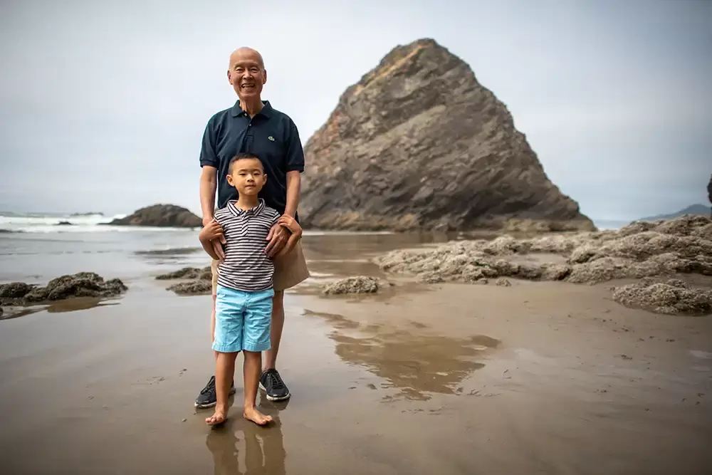 Grandfather and grandson, who is on the beach together there are waves and some rocks rising from the oceanPortland ​Family Photographer Robert Knapp - Book Today! ​Family Photographer Robert Knapp in Portland - Book Today!
