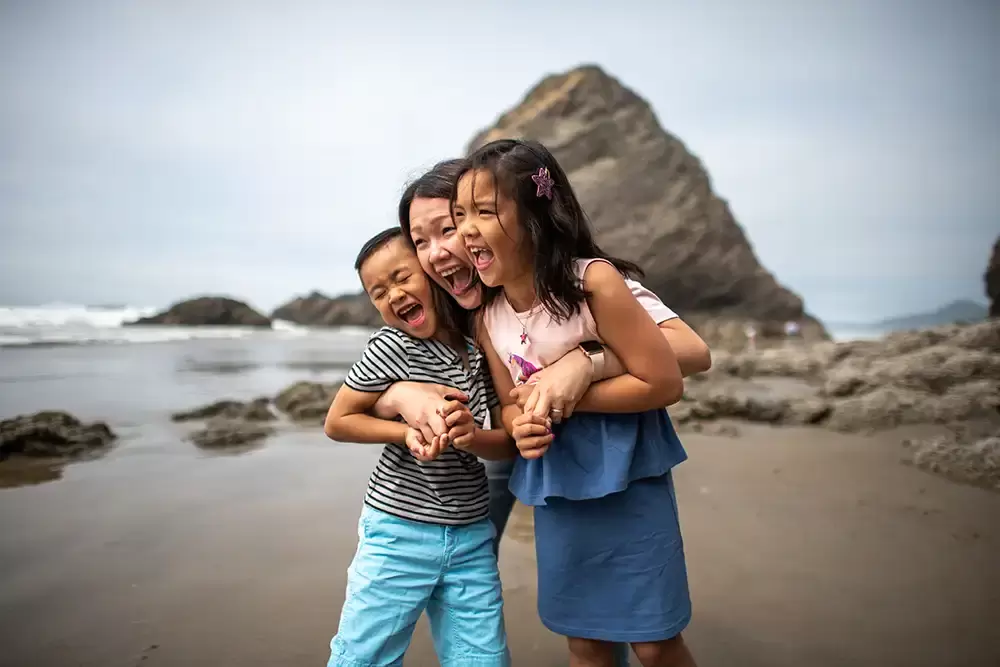 Mother poses with her children, waves and rocks are there in the background Portland ​Family Photographer Robert Knapp - Book Today! ​Family Photographer Robert Knapp in Portland - Book Today!