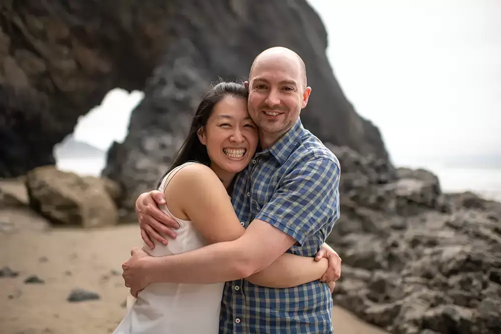 Oh man, woman with arms around each other big smiles on the beach Portland ​Family Photographer Robert Knapp - Book Today!​Family Photographer Robert Knapp in Portland - Book Today!