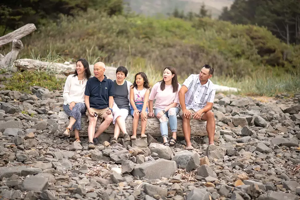 The whole family sits on the Driftwood log sitting on the beach Portland ​Family Photographer Robert Knapp - Book Today!​Family Photographer Robert Knapp in Portland - Book Today!