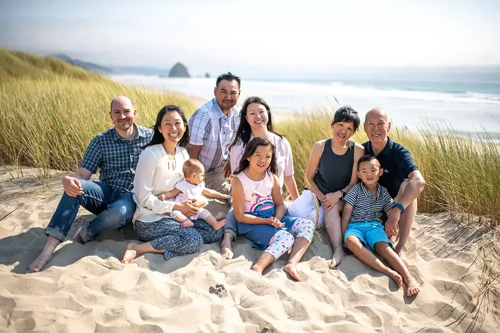 an extended family poses for a photo on the beach. The ocean is in the background. Portland ​Family Photographer Robert Knapp - Book Today! ​Family Photographer Robert Knapp in Portland - Book Today!
