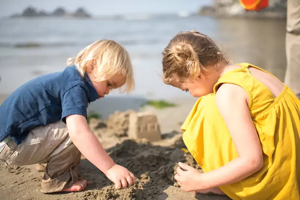 family photo beach ideas a little boy and girl make a sand castle together next to the ocean   Family Pictures Beach Theme with Portland Family Photographer Robert Knapp