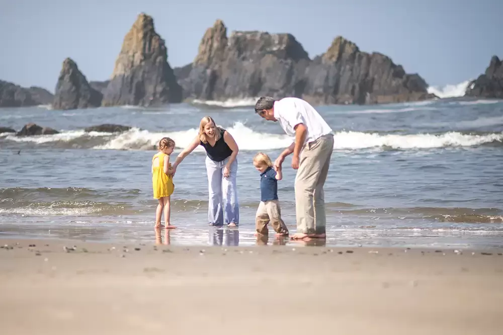 a family runs on the beach for a fun photo   Family Pictures Beach Theme with Portland Family Photographer Robert Knapp
