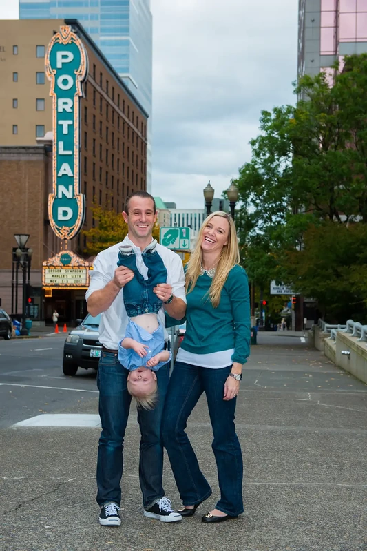 A family stands together in a silly pose in front of the portland marquee. Family Photography by Robert Knapp in Portland City Parks Portland Family Photographers
on Location 
City Parks