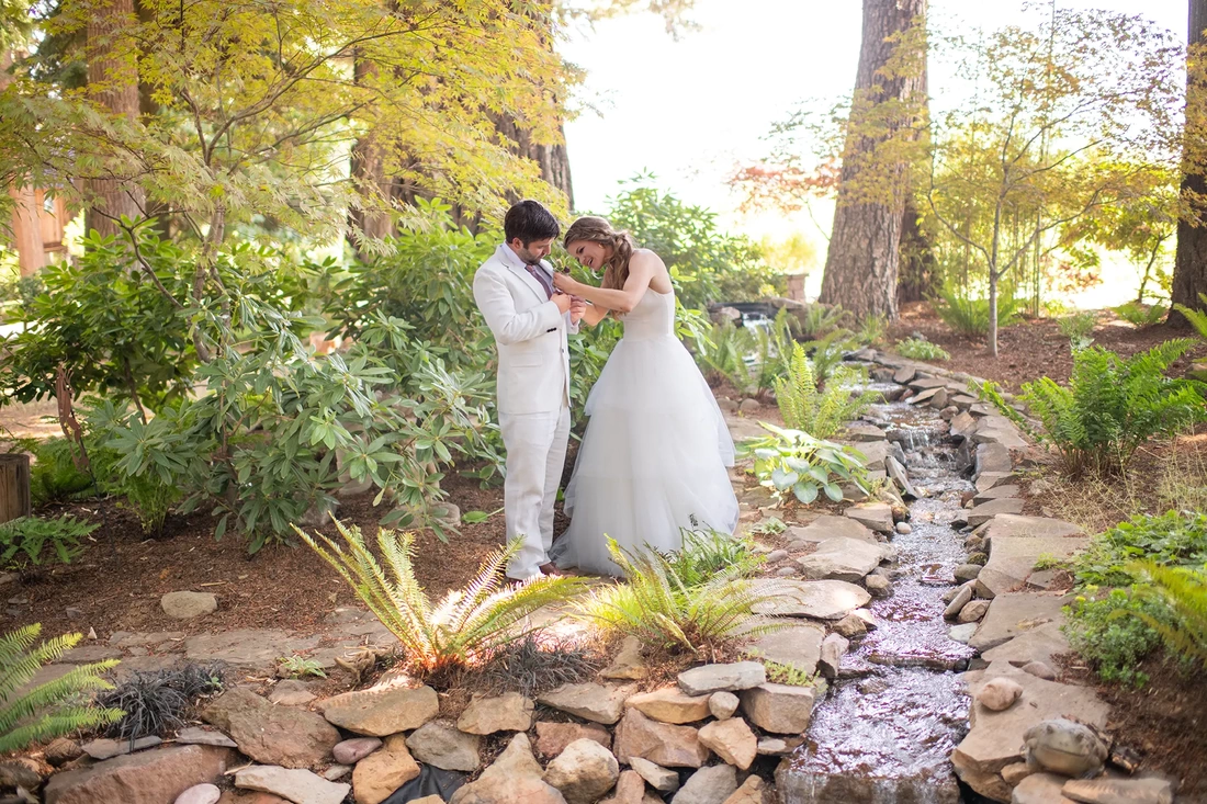 Portland Oregon Wedding Photographer Robert Knapp at ​Miller Farm bride fixes the grooms flower on his jacket