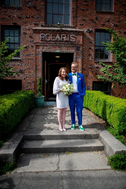 Bride and groom stand on the front steps of the Polaris Hall
