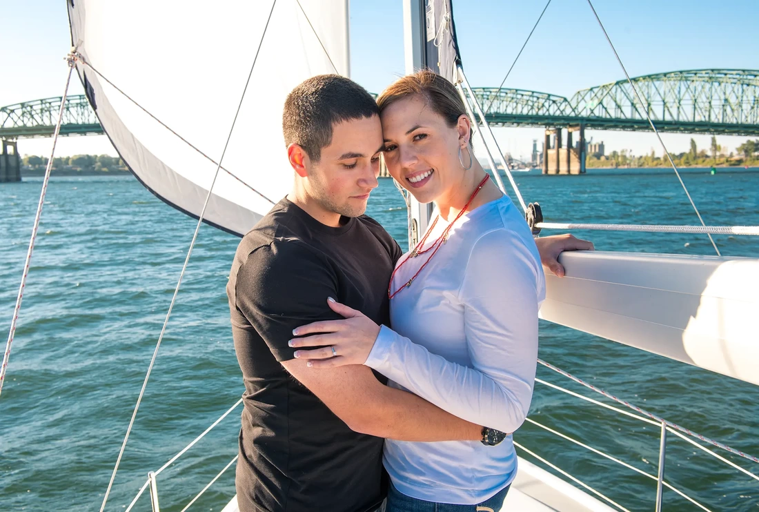 Sails out, Rigging around, this couple stands in the shade on the sailboat, cuddling