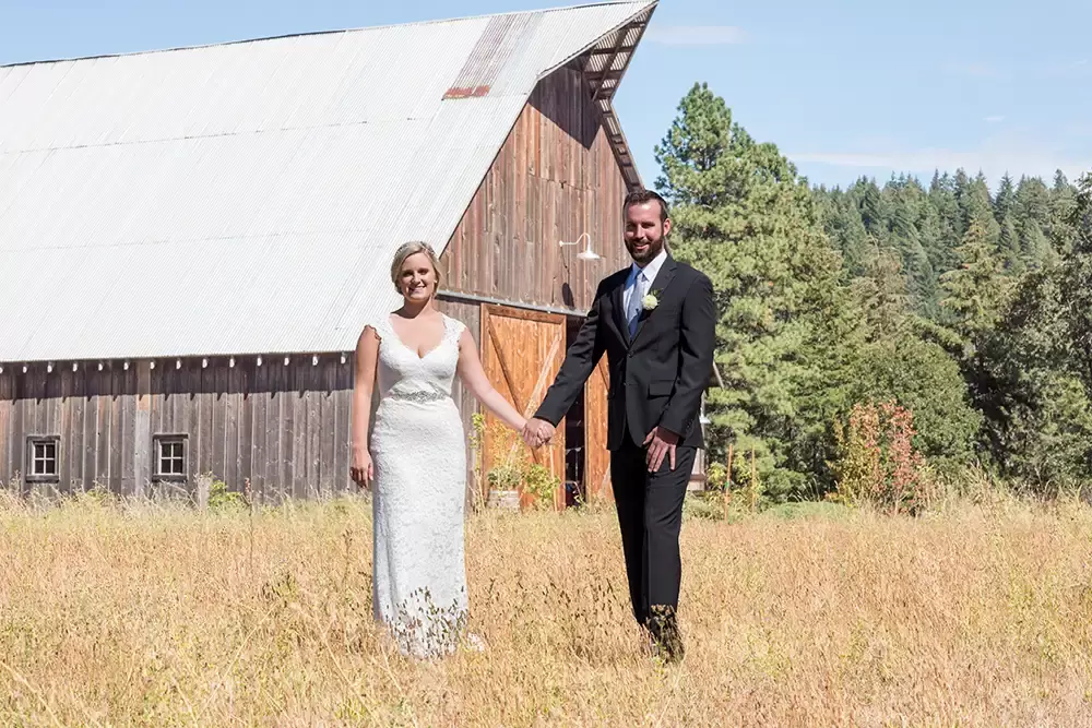 Tin Roof Weddings Barn Weddings Venues Near Me from Photographer Robert Knapp Bride and groom, hold hands in front of a barn